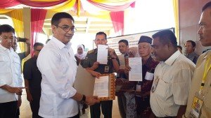 Direktur Rumah Swadaya Ditjen Penyediaan Perumahan Kementerian PUPR Raden Johny Sofyan Fajar Subrata (kiri) memberikan buku tabungan Program Bantuan Stimulan Perumahan Swadaya (BSPS) atau bedah rumah kepada warga Prabumulih, Sumsel di Pendopo Rumah Dinas Walikota Prabumulih, Senin (10/7).